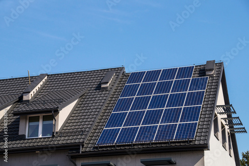 The roof of the building made of metal tiles. Installed solar panels.