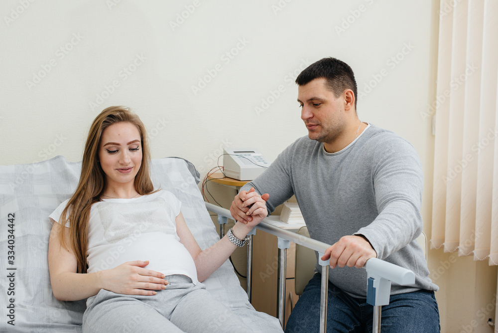 Fototapeta premium Pregnant girl in the clinic for consultation with the future father. Medical examination