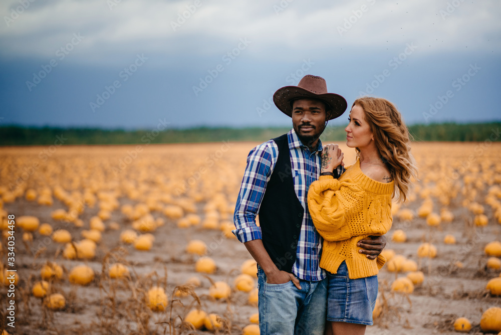 Portrait of a happy young couple of farmers on the background of a pumpkin crop. Portrait of a happy young couple of farmers on the background of a pumpkin crop.