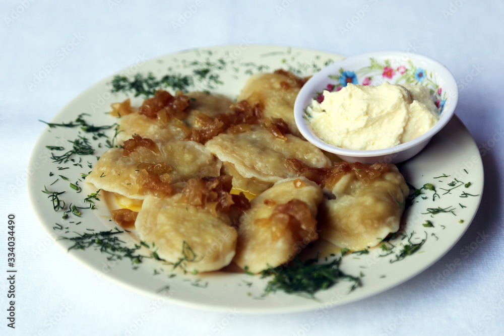 Dumplings with Fried Onions and Sour Cream, dishes of Russian national cuisine Dumplings with Fried Onions and Sour Cream, dishes of Russian national cuisine