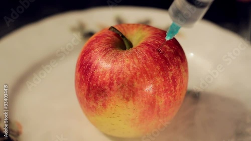 Apple is pierced with a medical needle.