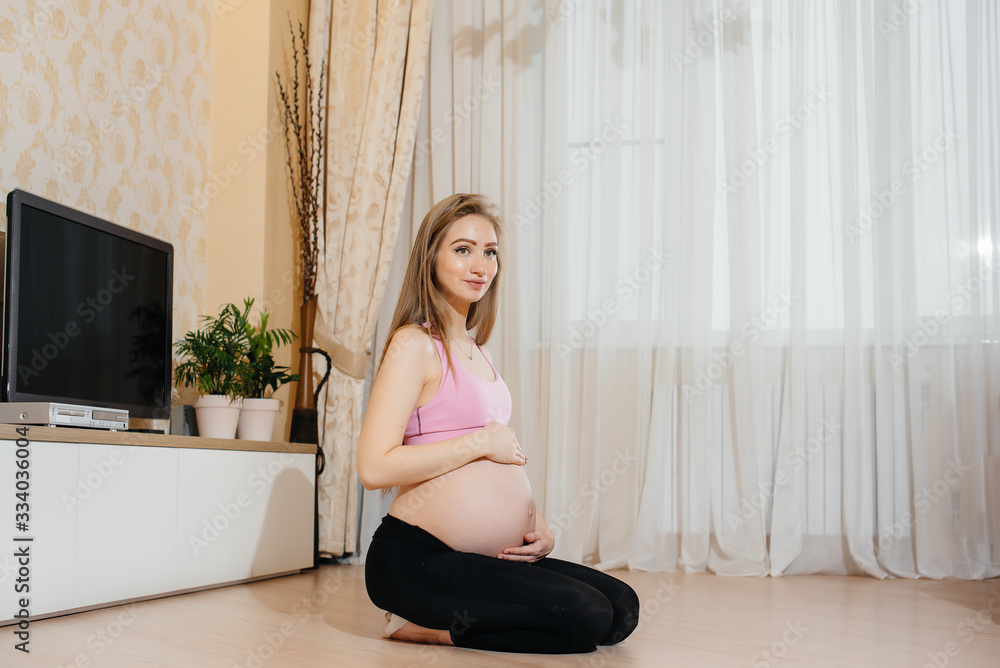 A pregnant girl does yoga at home. Health A pregnant girl does yoga at home. Health