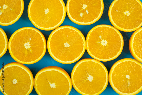orange vibrant oranges laid out on a blue background with place for text top view, citrus vitamin fruits, organic healthy food