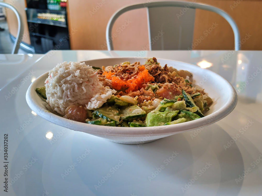 Spicy ahi tuna and salmon poke bowl, filled with avocado, mixed greens, rice Spicy ahi tuna and salmon poke bowl, filled with avocado, mixed greens, rice
