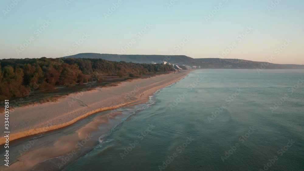 Drone flight over beautiful empty sandy beach with turquoise green sea and hotels from nearby resort village early in the morning, the Black sea coast next to Albena resort, Bulgaria Drone flight over beautiful empty sandy beach with turquoise green sea and hotels from nearby resort village early in the morning, the Black sea coast next to Albena resort, Bulgaria
