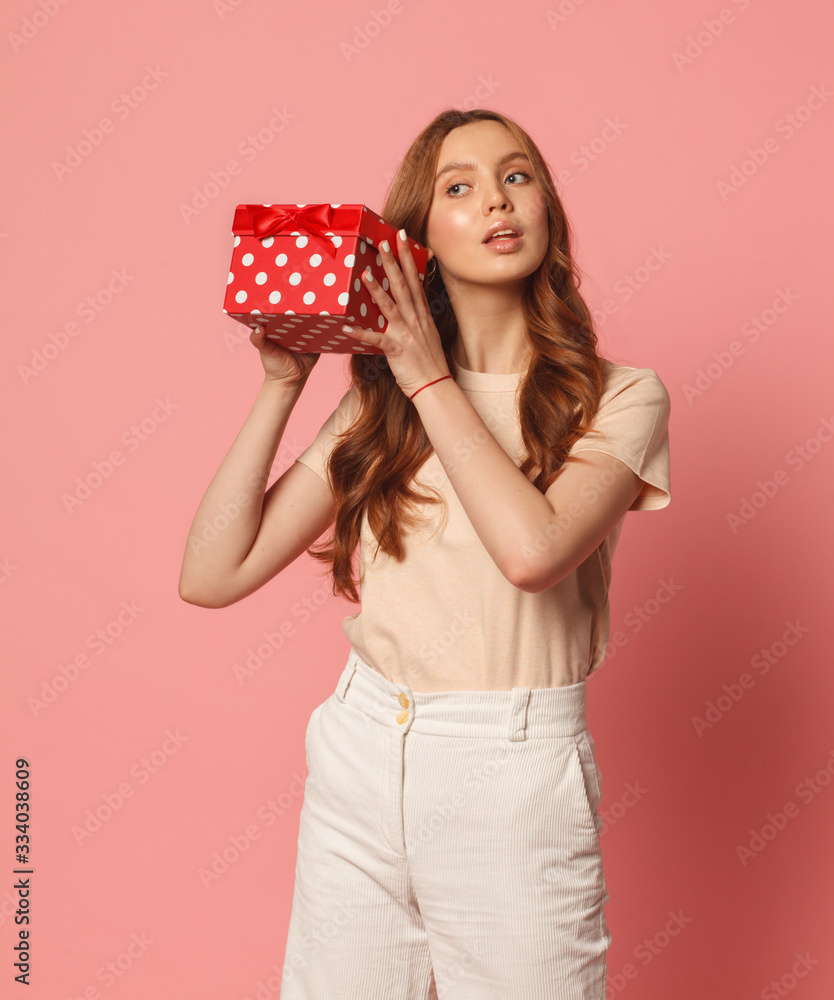 happy young woman with red gift box isolated on pink background happy young woman with red gift box isolated on pink background