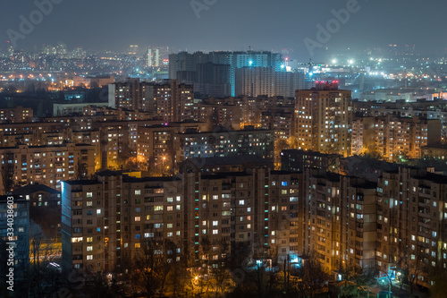 Aerial view of residential area with multi-storey panel houses at night.