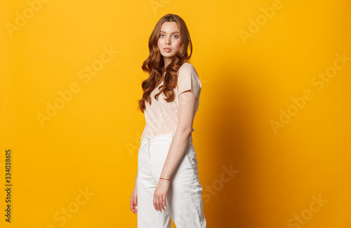 young fashion caucasian woman posing isolated on yellow background