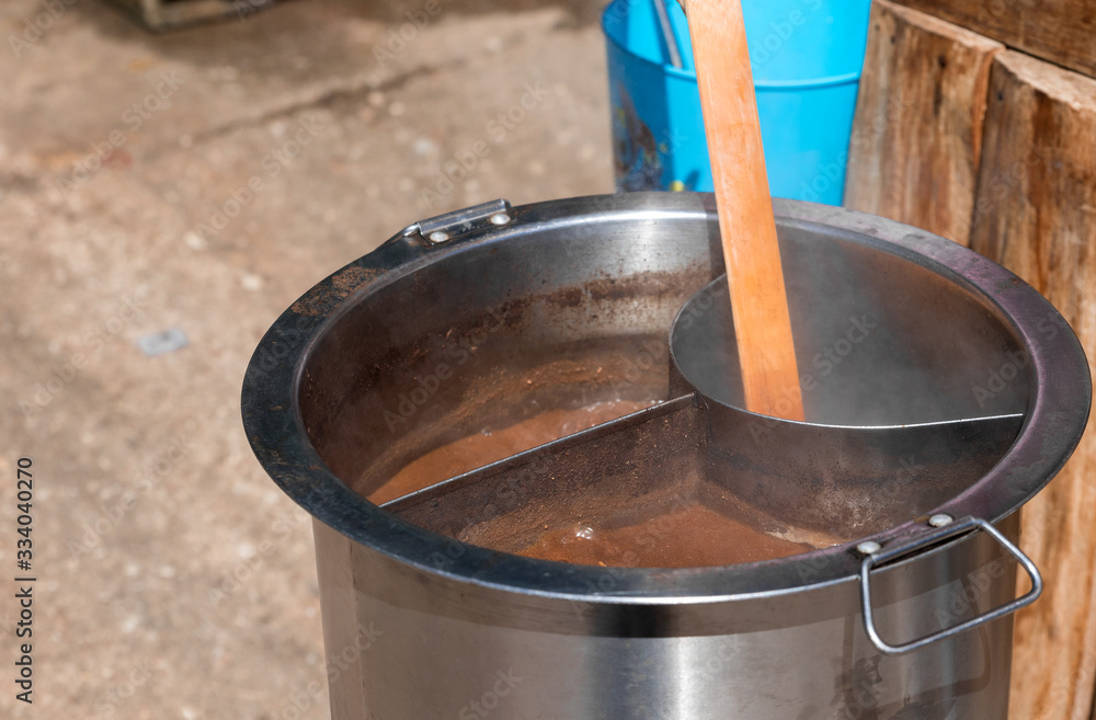 Close up view and copy space. Metal pot is boiling noodle soup with steam and stain brown. Close up view and copy space. Metal pot is boiling noodle soup with steam and stain brown.