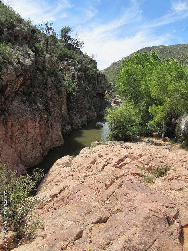 View over a cliff on the Water Wheel Falls hiking trail in Payson, Arizona, with Ellison Creek running below View over a cliff on the Water Wheel Falls hiking trail in Payson, Arizona, with Ellison Creek running below
