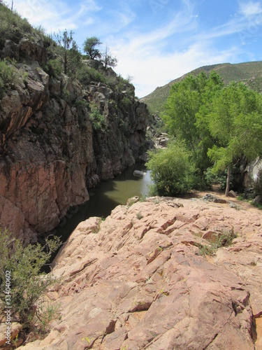 View over a cliff on the Water Wheel Falls hiking trail in Payson, Arizona, with Ellison Creek running below