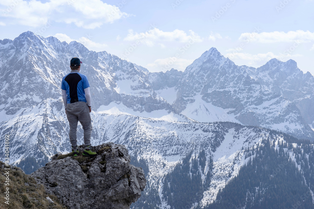 Junger Mann beim Bergsteigen in den Alpen. Mit Imposanten Bergmassiven im Hintergrund