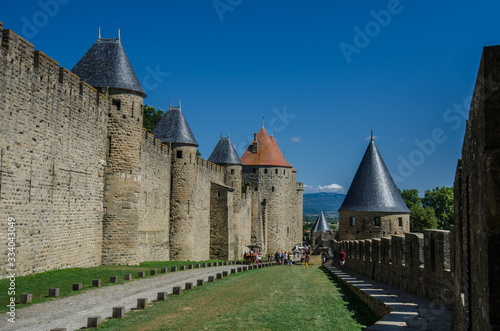 Picturesque walls of medieval  castle with metal roofs observing towers.