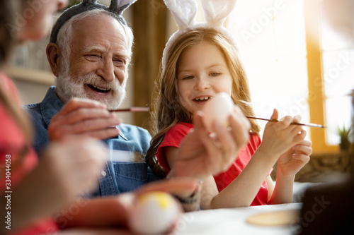 Εκτύπωση καμβά Excited grandfather and granddaughter painting eggs stock photo