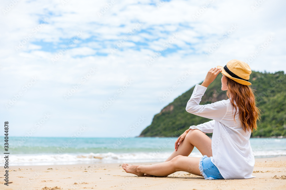 Portrait pretty woman and hat sitting on the beach