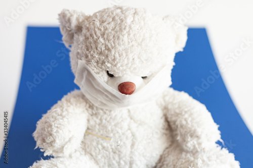 teddy bear in medical mask on a classic blue background