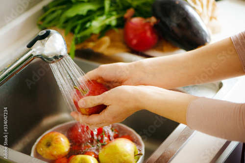 Washing fruit in the kitchen, white hands