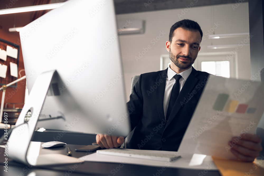 Concentrated young office clerk working in his office Concentrated young office clerk working in his office