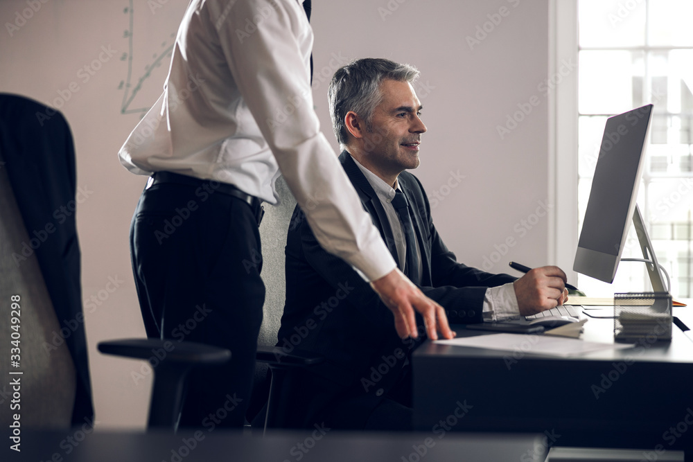 Male colleagues looking at screen of laptop Male colleagues looking at screen of laptop