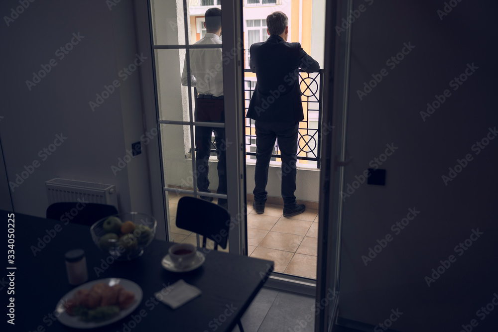 Business partners talking to each other after lunch in balcony Business partners talking to each other after lunch in balcony