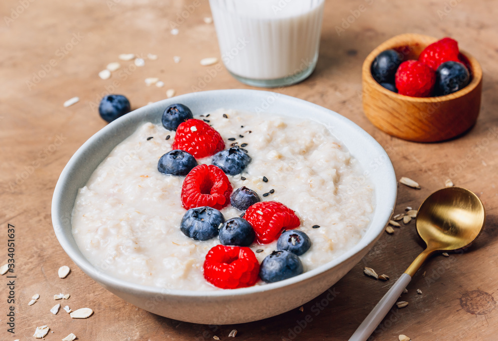 Breakfast oatmeal porridge with fresh berries and almond milk. Healthy vegan food concept. Top view. Copy space. Flat lay Breakfast oatmeal porridge with fresh berries and almond milk. Healthy vegan food concept. Top view. Copy space. Flat lay