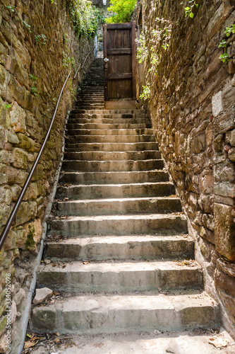 Fototapeta Naklejka Na Ścianę i Meble -  narrow outdoor stone stairway between drystone walls