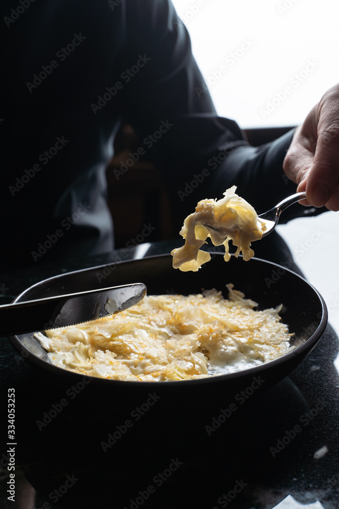 Man is eating custard banana pudding with knife and fork Man is eating custard banana pudding with knife and fork