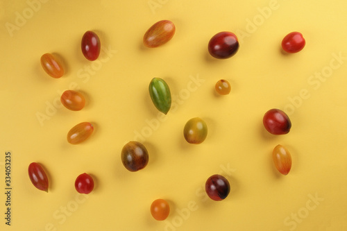 Fresh ripe mixed tomato verity assorted color on yellow background