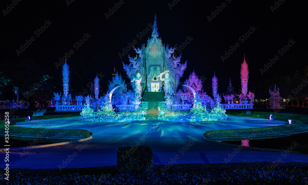 Night view of Wat Rong Khun (other name White temple) with illuminated lights. One of iconic tourist attraction place in Chiang Rai province of Thailand.