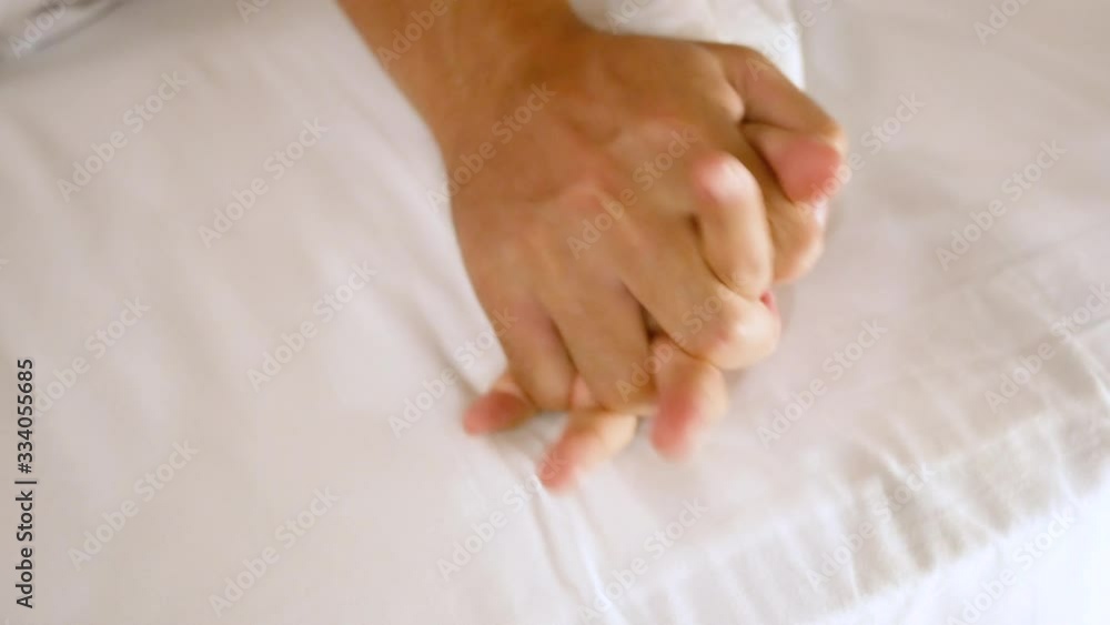 Close-up hand of Young couple making love under white blanket on the bed. Close-up hand of Young couple making love under white blanket on the bed.