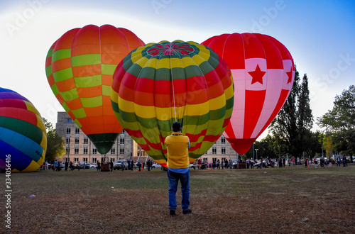Man at Canberra balloon festival holding hot air balloon 