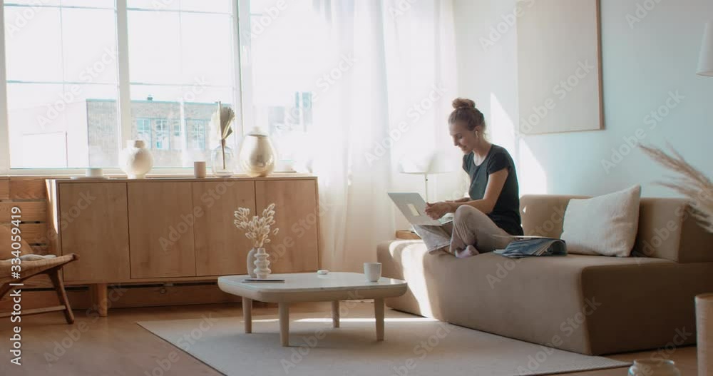 Caucasian female working on a laptop from home, having a video call on a sofa. Stay home, quarantine remote work. Shot on RED Dragon Caucasian female working on a laptop from home, having a video call on a sofa. Stay home, quarantine remote work. Shot on RED Dragon