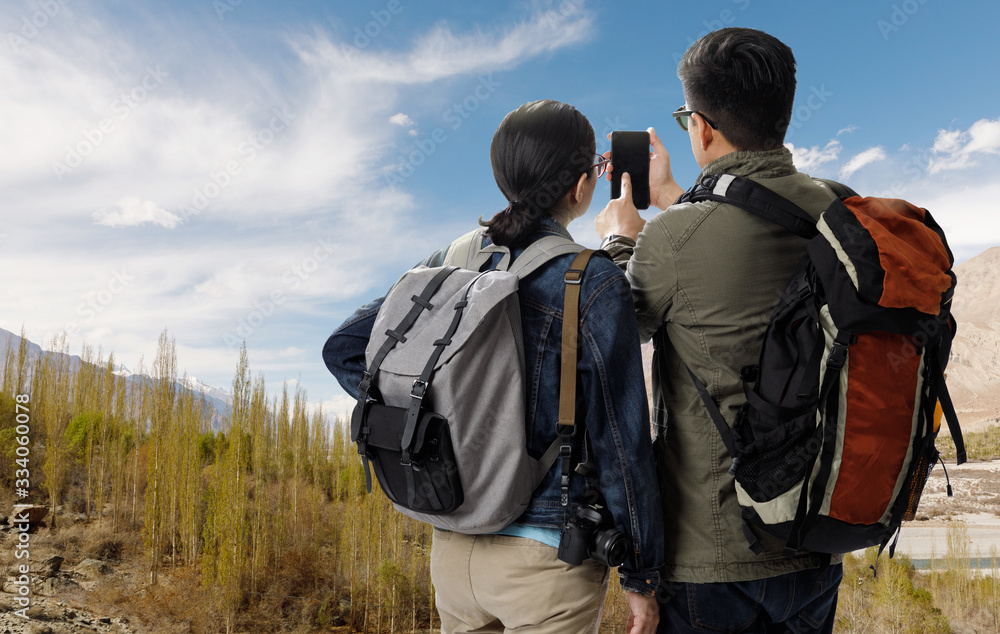 Young traveler man and girl with the backpack on the top of mountain and using smartphone searching direction on location map,Adventure and travel in the concept, Travelling tour in Asia:Leh Ladakh Young traveler man and girl with the backpack on the top of mountain and using smartphone searching direction on location map,Adventure and travel in the concept, Travelling tour in Asia:Leh Ladakh