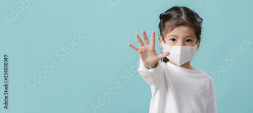 Asian little child girl is wearing medical face masks to protect themselves from pollution Coronavirus flu virus, New coronavirus 2019-nCoV from China, Empty space isolated on blue long banner