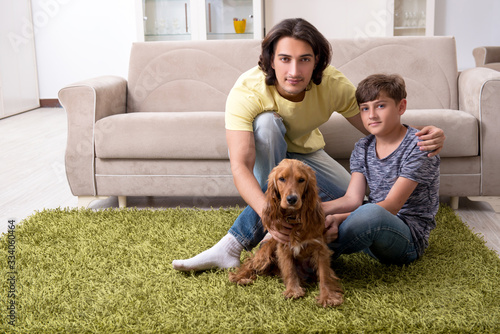 Young father and his son with cocker spaniel dog
