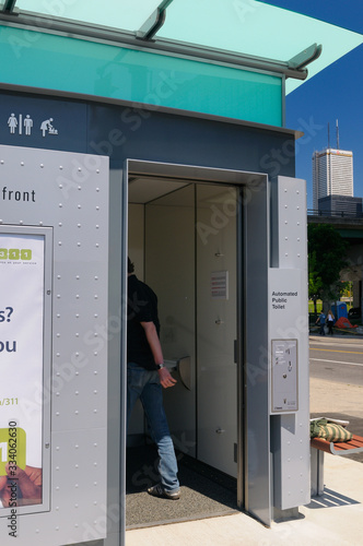 Man entering first new automated public pay toilet on the Toronto waterfront photo