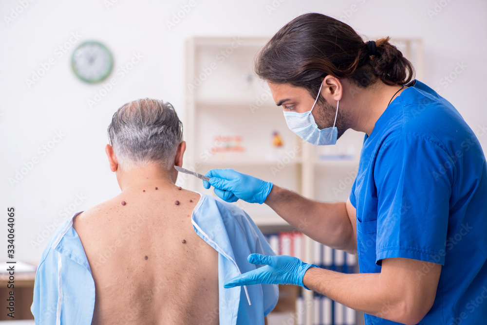 Old man visiting young male doctor dermatologist Old man visiting young male doctor dermatologist