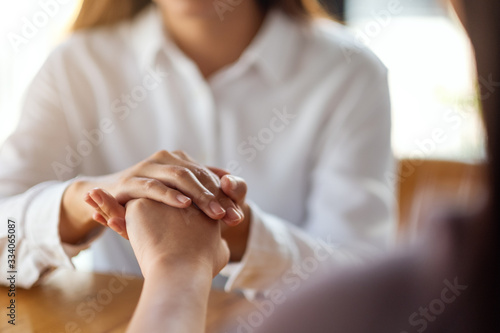 Women holding each other hands for comfort and sympathy