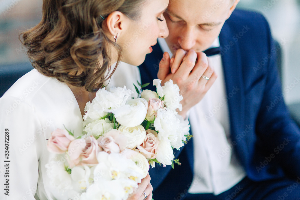 The bride and groom's romantic photo shoot. The newlyweds are happy together. Stylish modern couple in a light interior. The bride and groom's romantic photo shoot. The newlyweds are happy together. Stylish modern couple in a light interior.