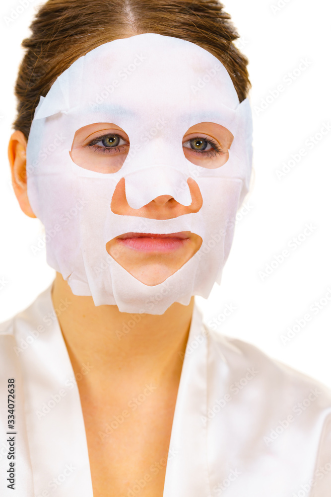 Woman applying sheet mask on face Woman applying sheet mask on face