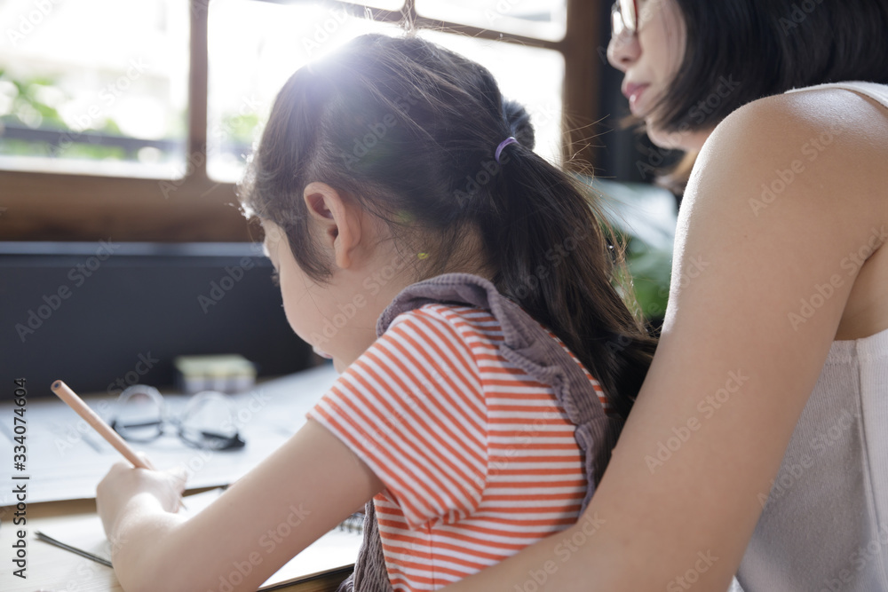 Fototapeta premium Businesswoman mother woman with a child girl working on the desk in the home, Quarantine isolation during the Coronavirus (COVID-19) health crisis
