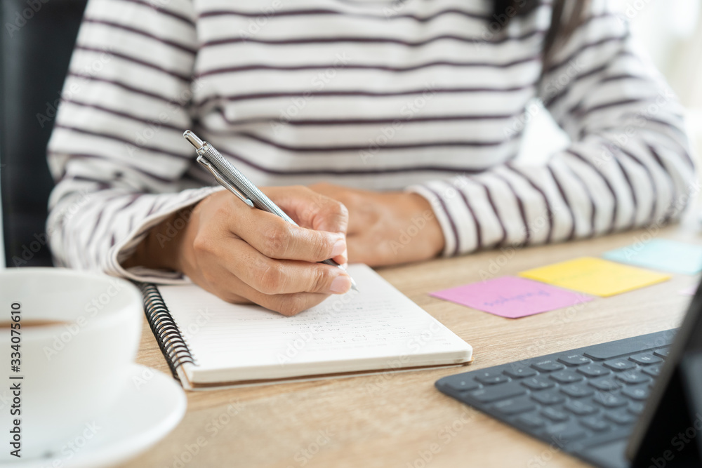 Hand Asian women write notebook with a pencil at the table in the home office, Businesswoman work from home Hand Asian women write notebook with a pencil at the table in the home office, Businesswoman work from home
