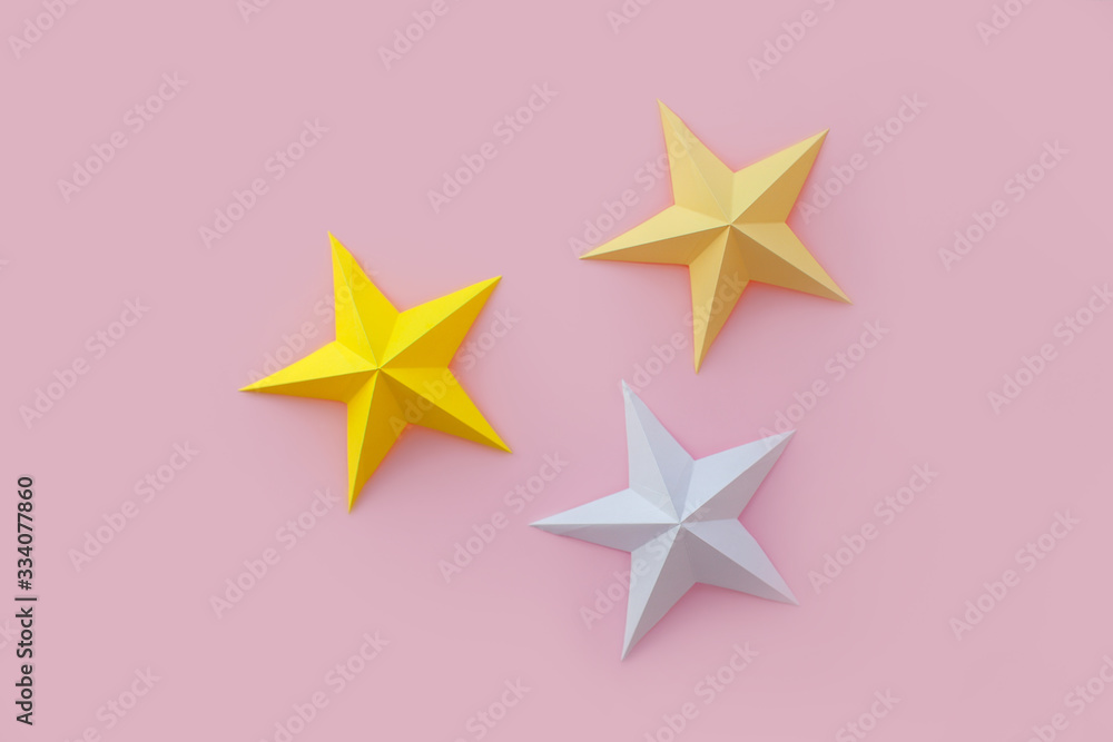 Handmade paper art and cut white and yellow stars on pink background. Handmade paper art and cut white and yellow stars on pink background.