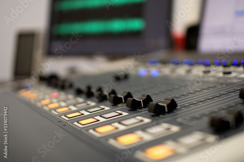 Professional audio mixing console with faders and adjustment knobs.