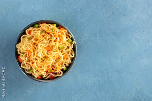 Instant noodles with carrot, scallions, and a sauce, a vegetable soba bowl, overhead shot with copy space photo