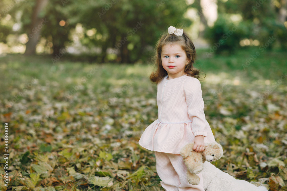 Cute little girl in a park. Child in a pink dress. Cute little girl in a park. Child in a pink dress.