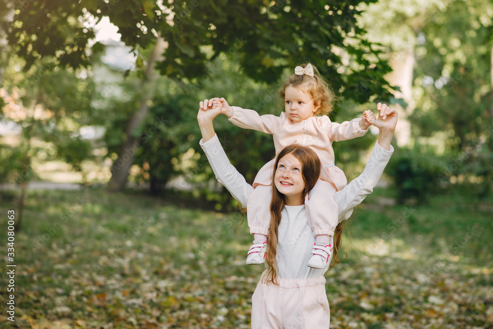 Children in a summer park. Sisters playing. Kids in a pink clothes. Children in a summer park. Sisters playing. Kids in a pink clothes.