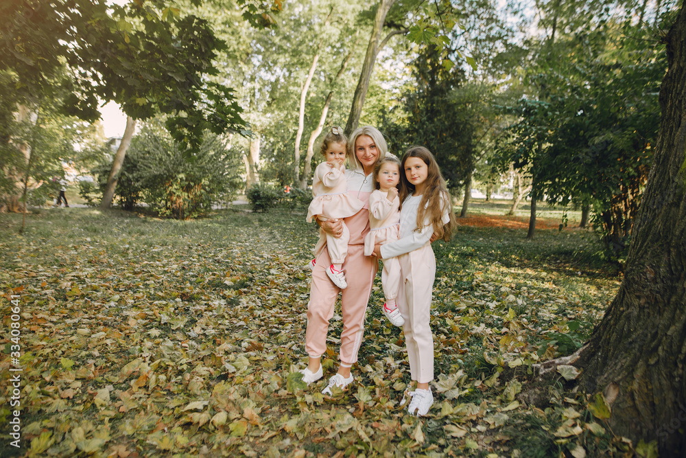 Fototapeta premium Family in a summer park. Mother in a pink suit. Little girl walking in a park.