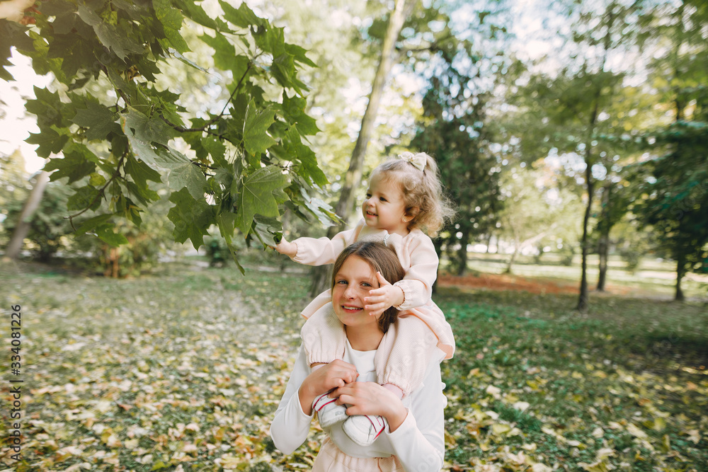 Children in a summer park. Sisters playing. Kids in a pink clothes. Children in a summer park. Sisters playing. Kids in a pink clothes.