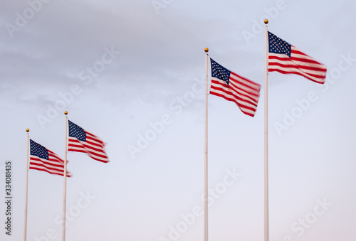 A row of waving US flags on the sky background